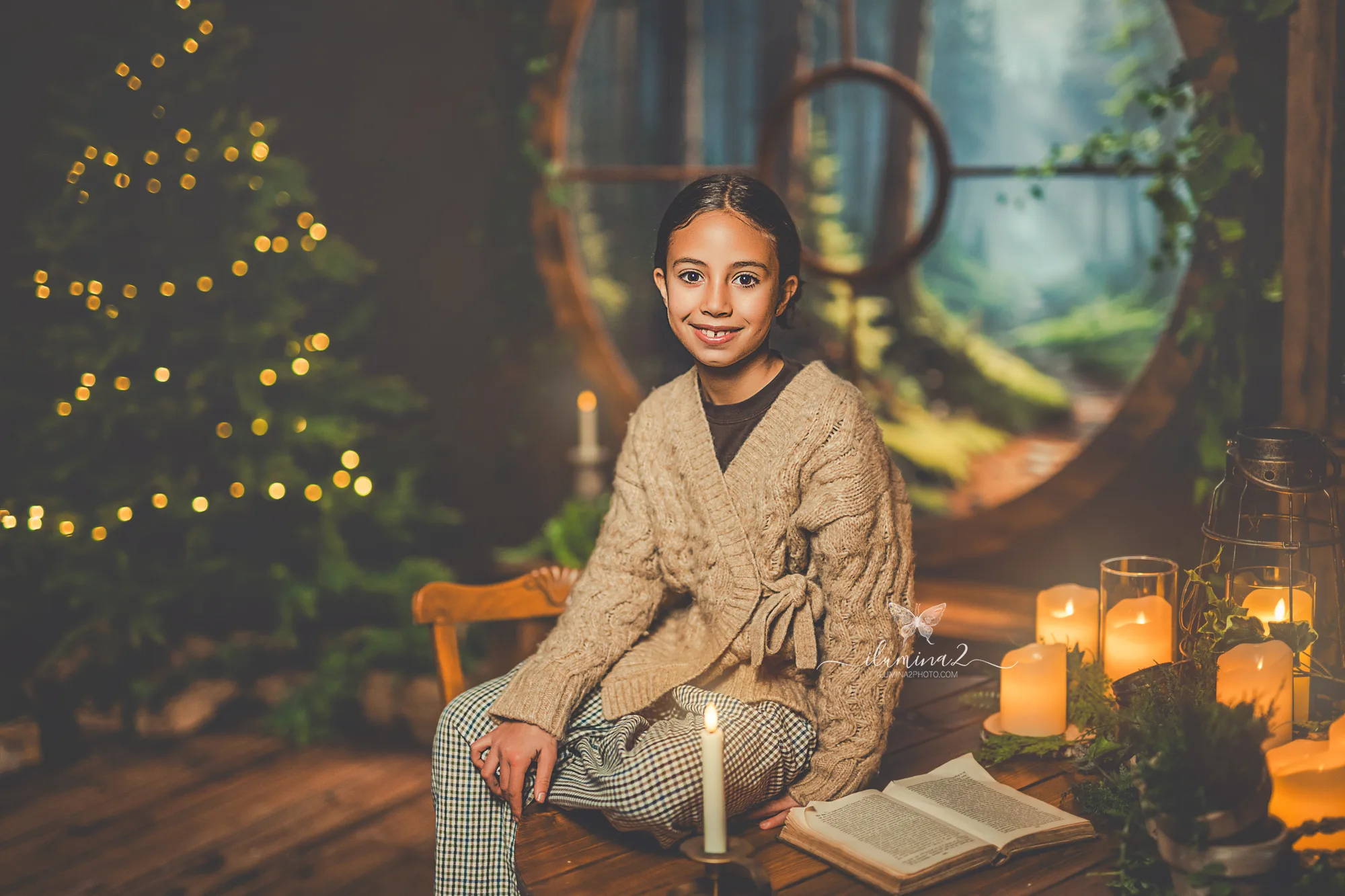 Retrato infantil navideño en estudio de Ilumina2 Photo, con luz cálida y decorado natural “La ventana del bosque”.