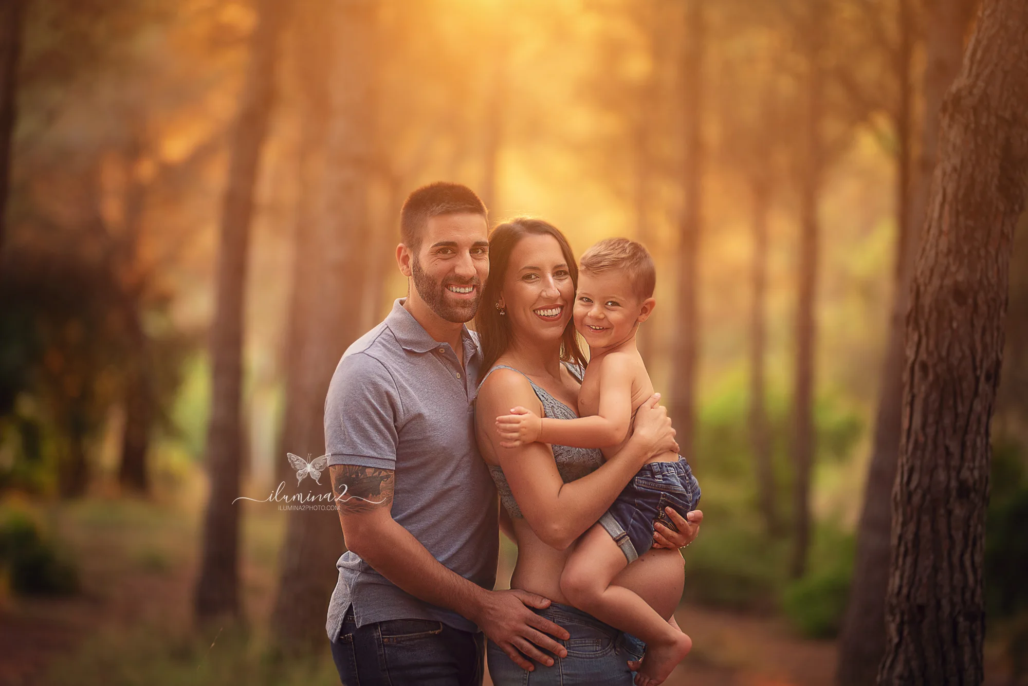 Familia durante una sesión de fotos de embarazo en un bosque de Barcelona