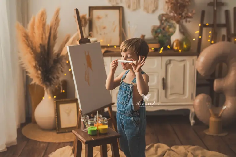 Niño con ropa neutra en una sesión de fotos infantil con pintura
