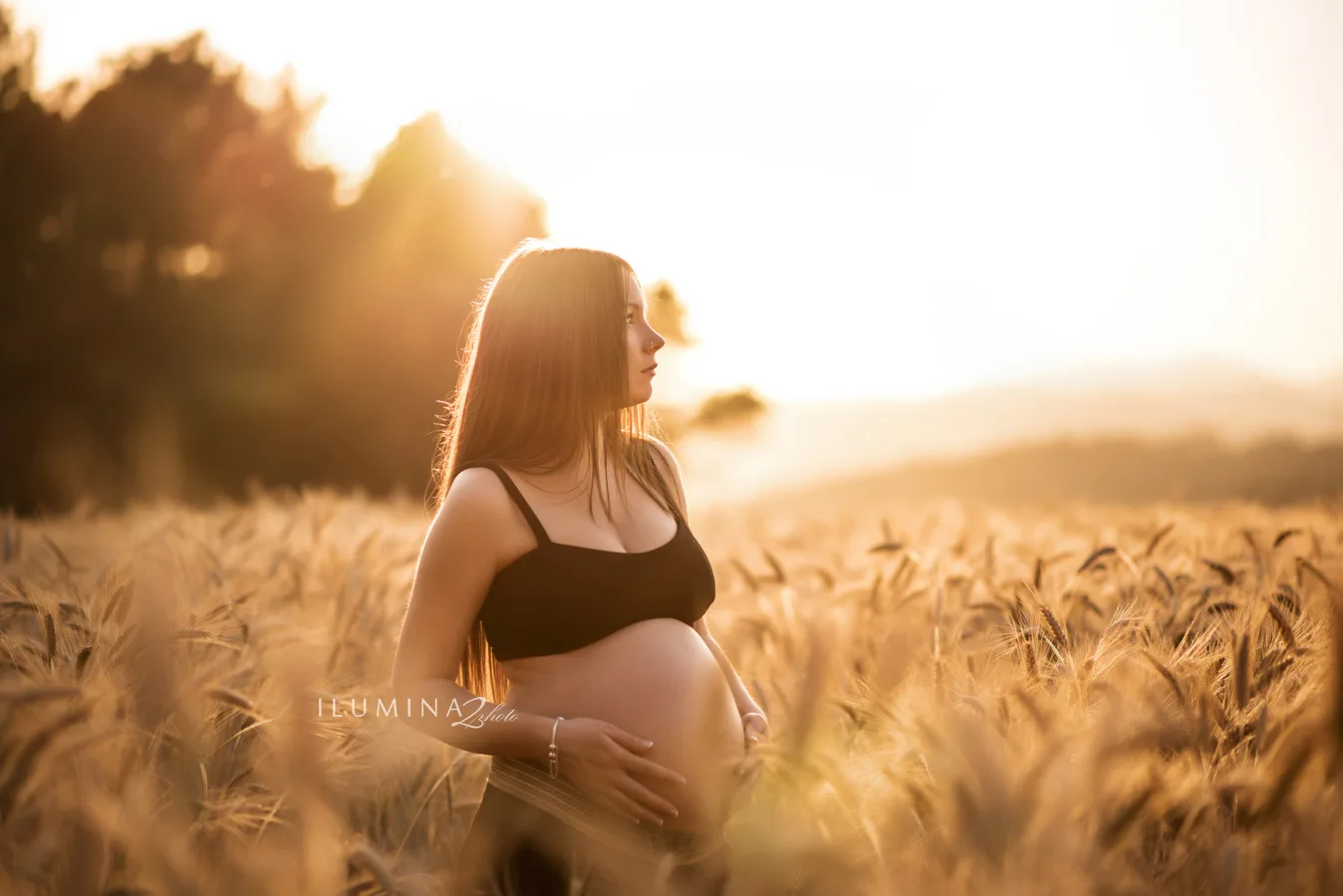 Mujer embarazada en una sesión premamá en un campo de Barcelona al atardecer