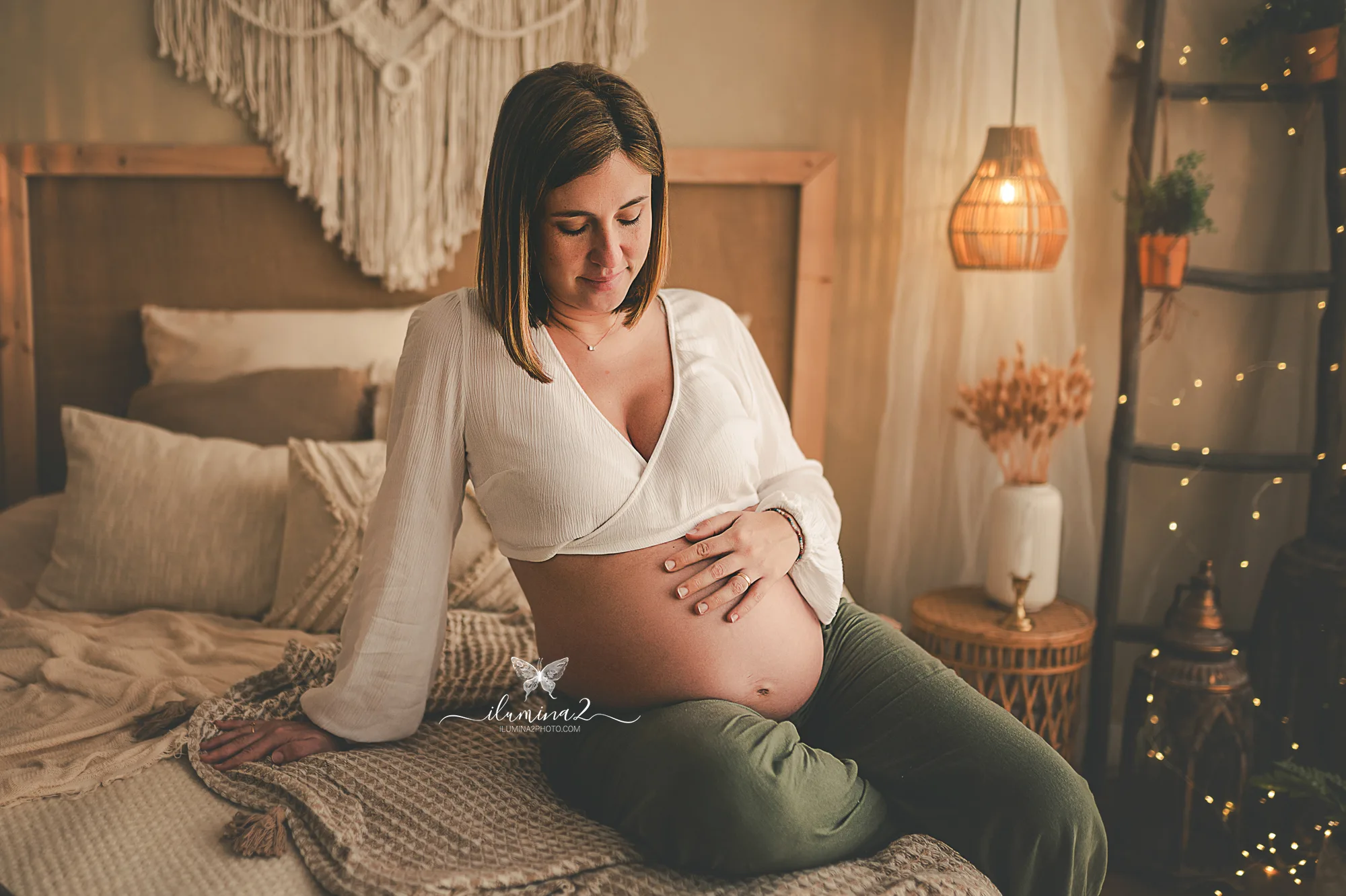 Mamá embarazada durante una sesión de fotos en estudio iluminada por luz natural de ventana