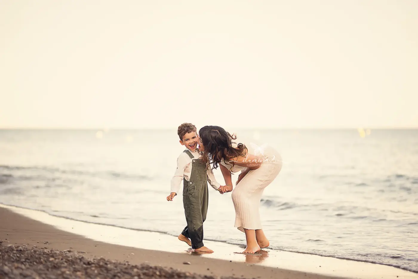 Dónde hacer fotos de familia en exterior cerca de Barcelona Ilumina2 Photo Familia jugando en la orilla de una playa del Garraf durante una sesión de fotos al atardecer