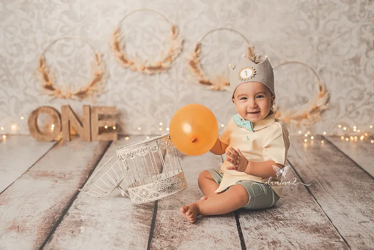 Bebé con corona jugando con un globo en su sesión de fotos de primer cumpleaños en Barcelona