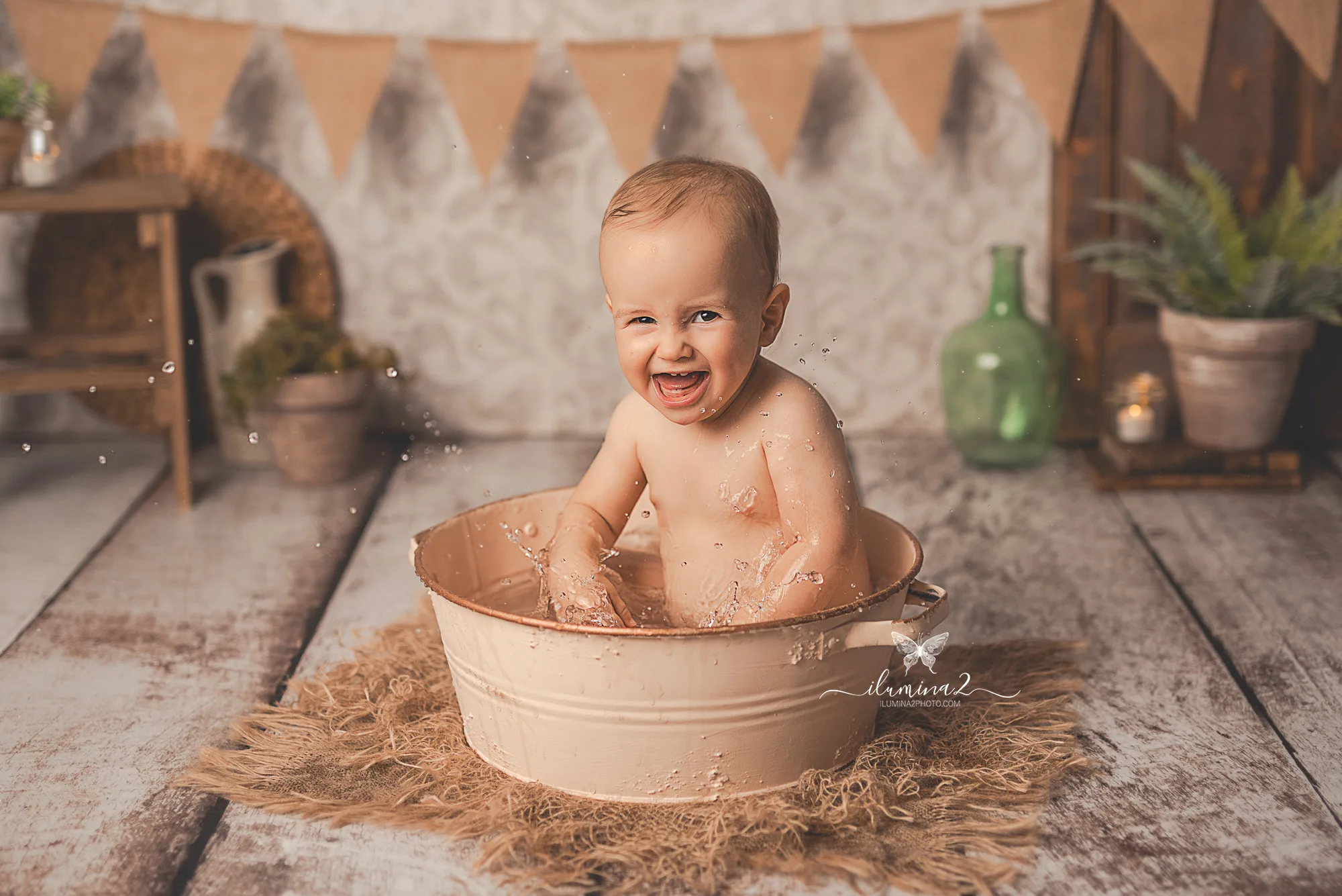 Bebé disfrutando del bañito con agua templada después de su sesión Smash Cake
