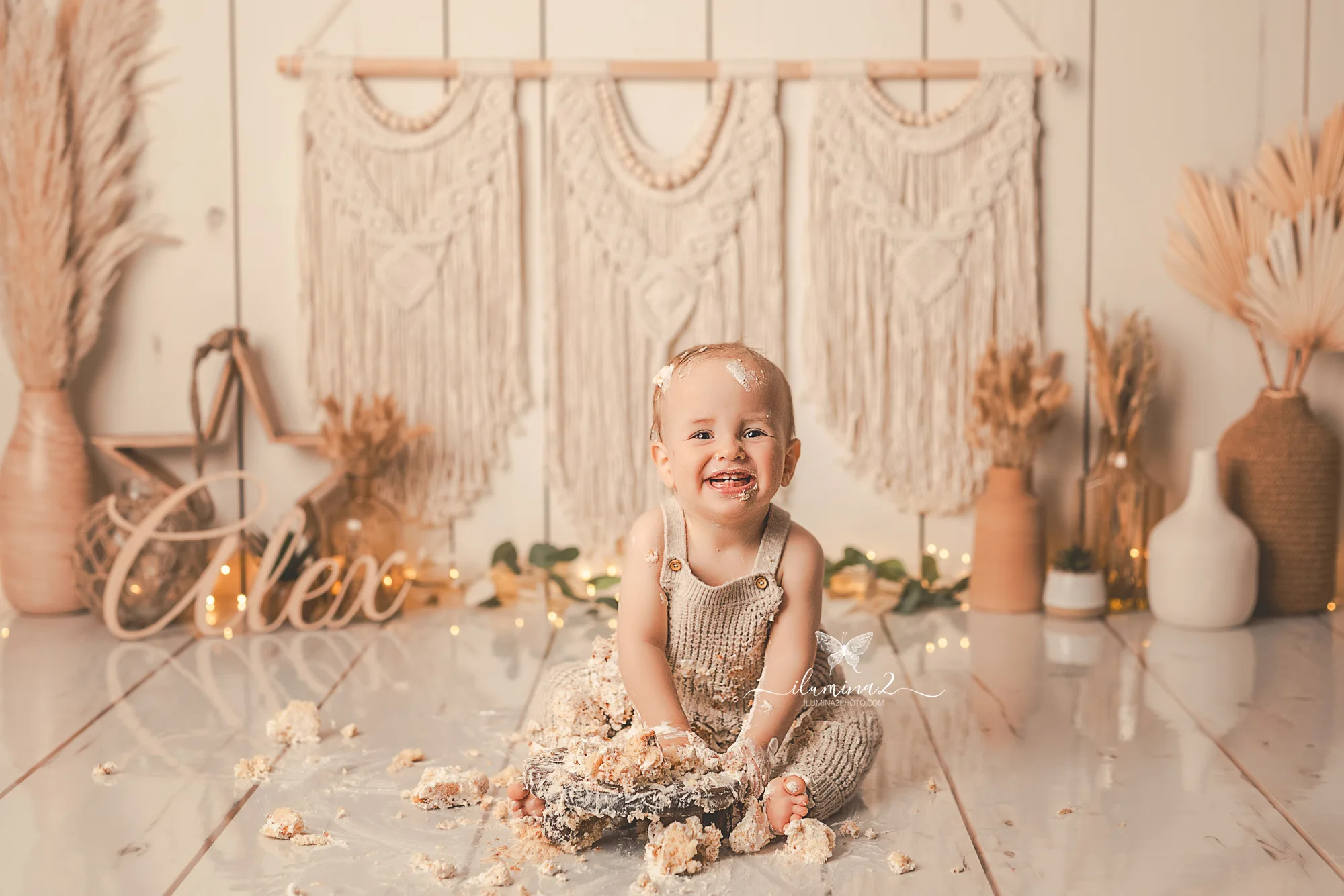 Bebé jugando con su pastel en un decorado boho durante una sesión Smash Cake en Barcelona