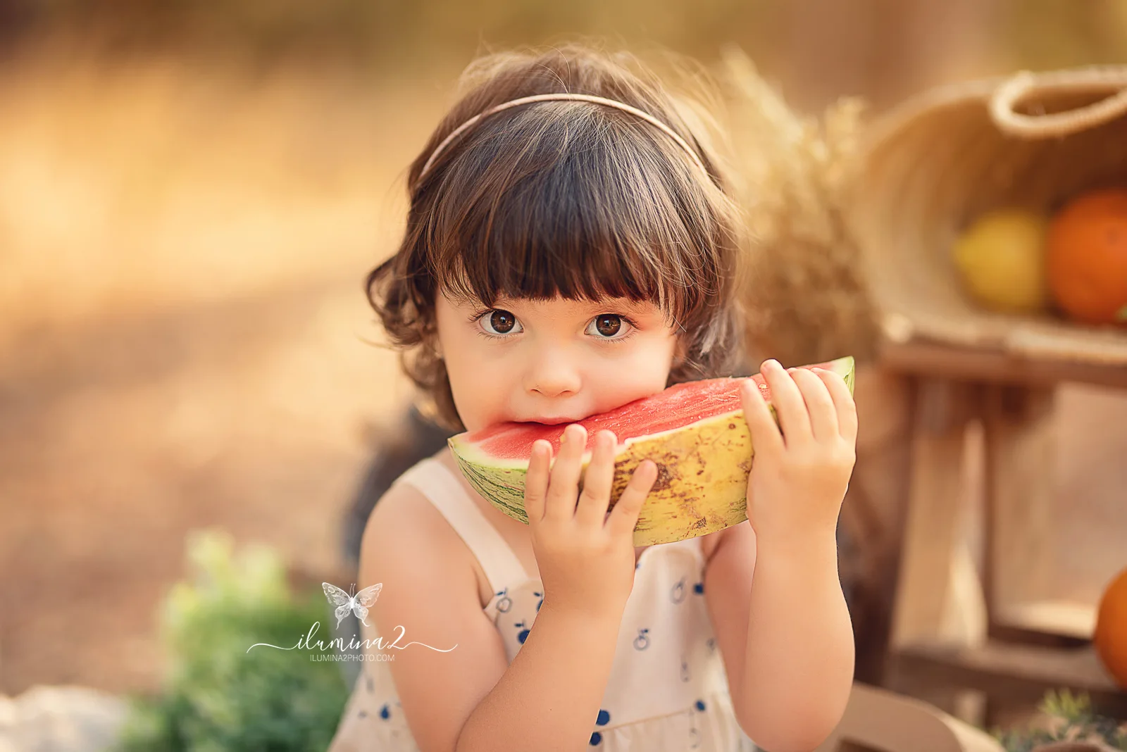 Bebé mordiendo un trozo de sandía en una sesión Smash Cake con fruta
