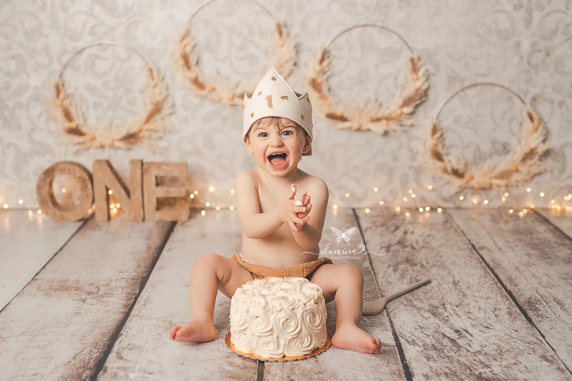 Bebé jugando con su pastel de nata en una sesión Smash Cake con decoración incluida