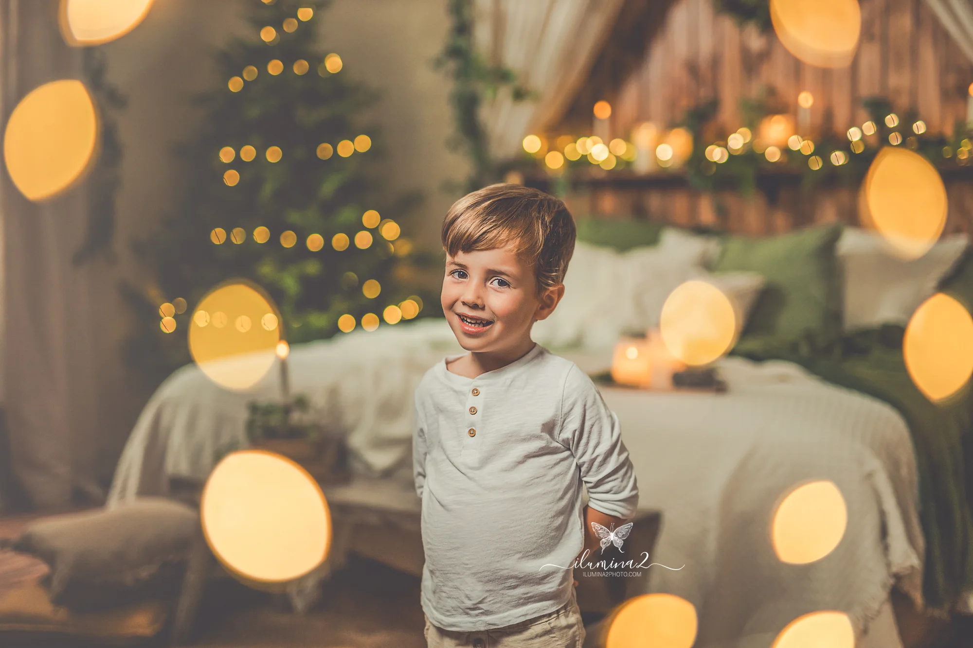 Fotografía de Navidad en Barcelona con luz cálida y un peque sonriendo entre luces de Navidad