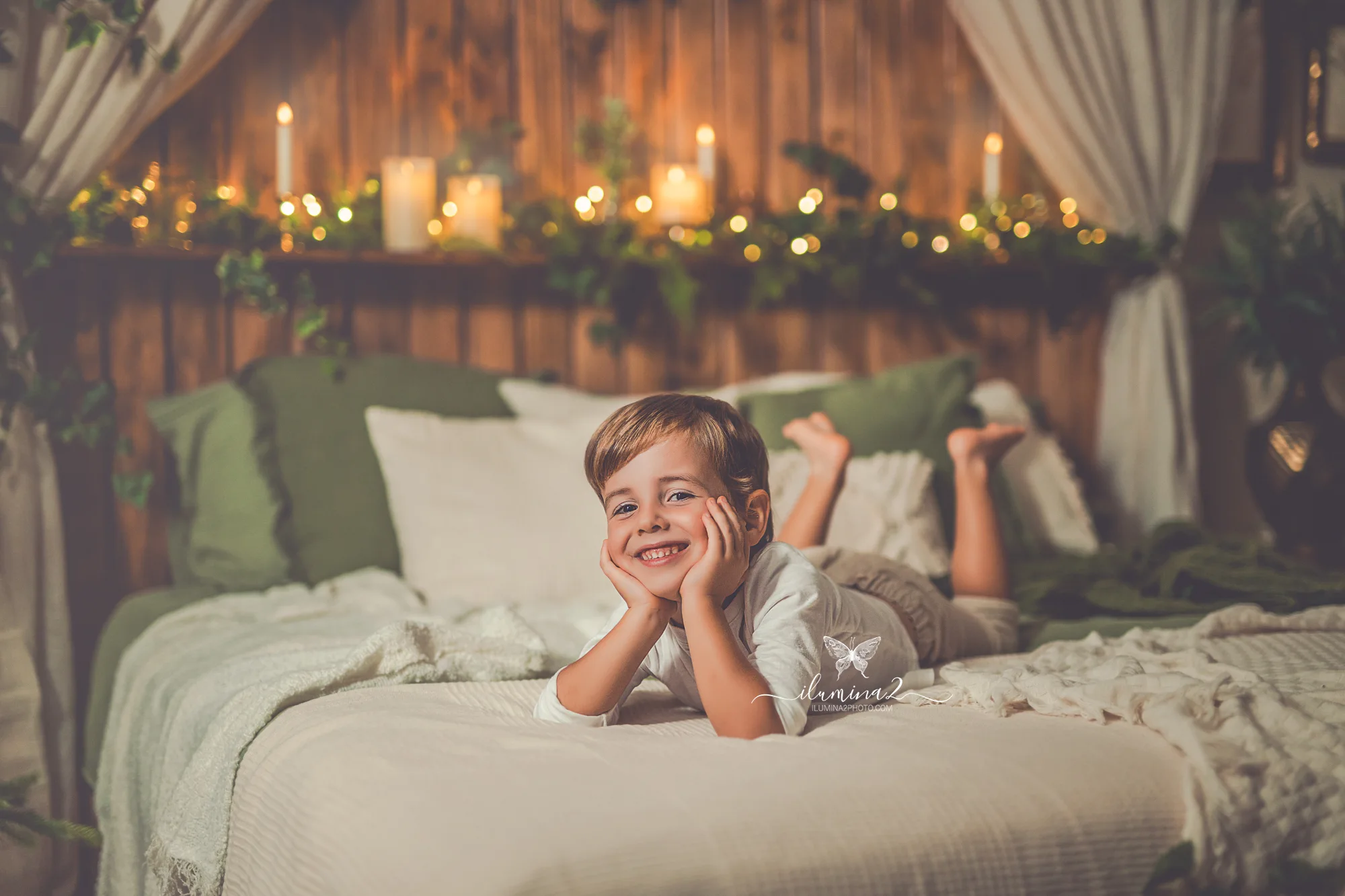 Sesiones de fotos de Navidad Ilumina2 Photo Niño riendo sobre la cama en su sesión navideña