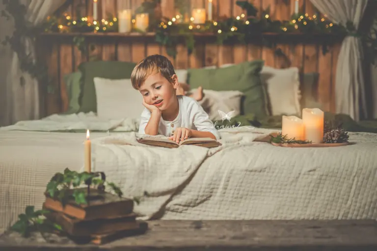 Niño sobre la cama del decorado navideño durante su sesión de fotos de Navidad en Barcelona