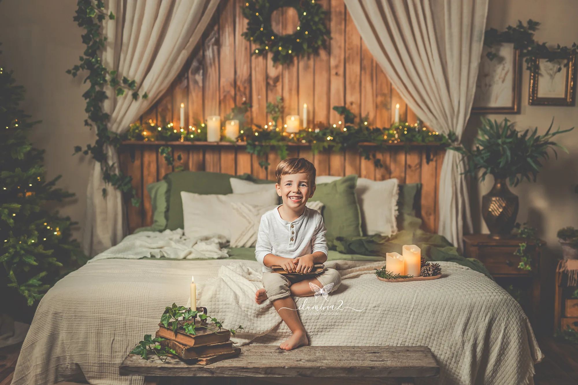Niño sobre la cama del decorado navideño durante su sesión de fotos de Navidad en Barcelona